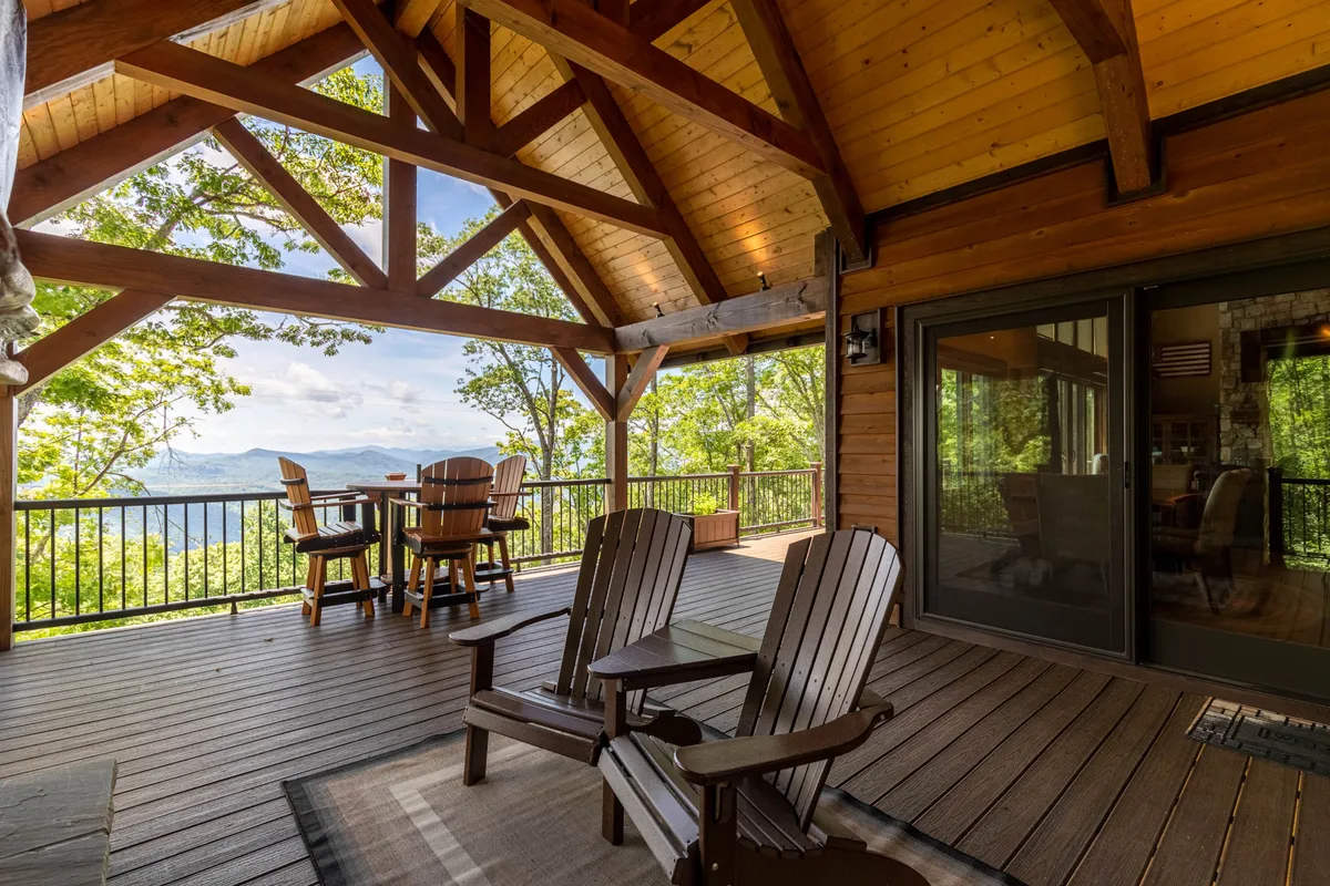 A spacious wooden deck with comfortable outdoor seating, offering a scenic view of the surrounding landscape. The deck is designed for relaxing and socializing while enjoying nature, perfect for gatherings under the sky.