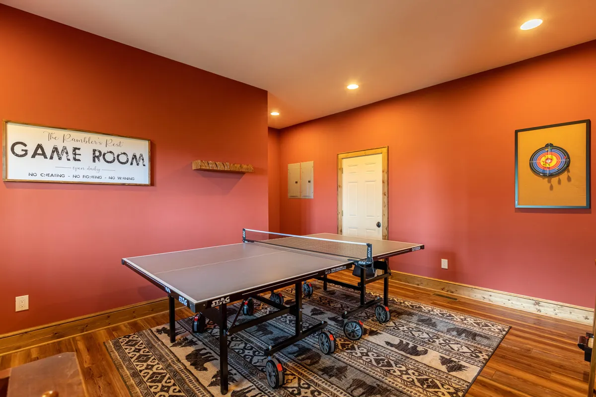 A vibrant game room featuring a ping pong table, playful wall art, and a welcoming atmosphere perfect for energetic activities and gatherings. The space is designed for social interaction and friendly competition, which aligns with the section's focus on entertainment and leisure.